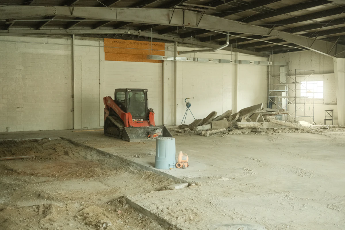 A large room with a bulldozer and a bucket