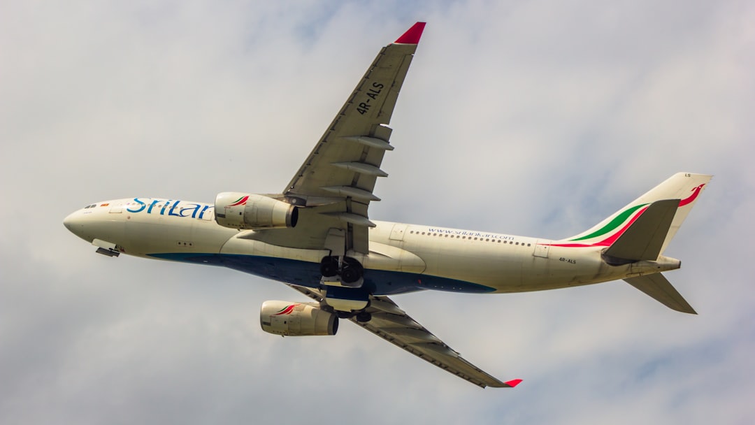 a large passenger jet flying through a cloudy sky, Srilankan A330-200
