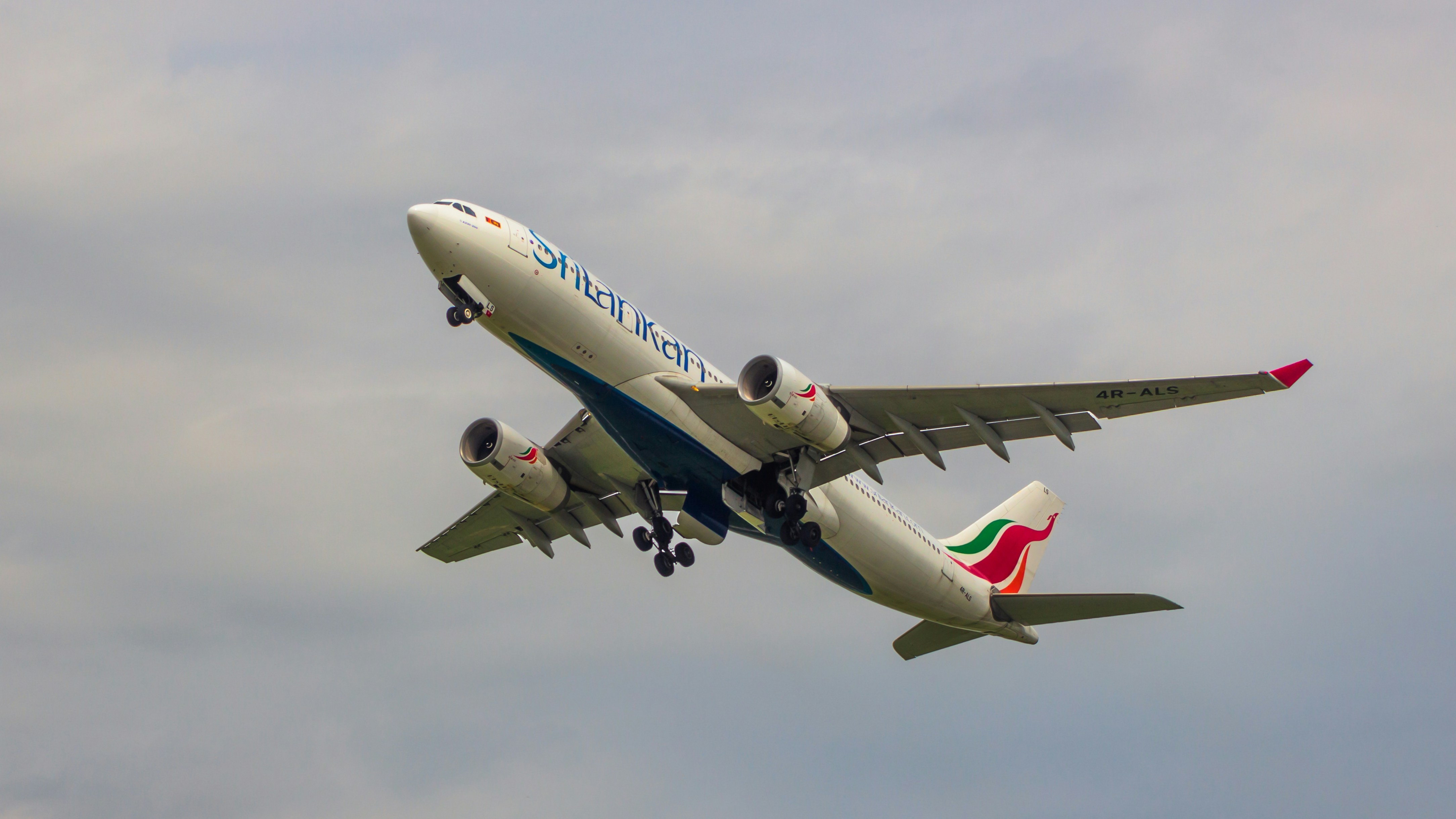 a large jetliner flying through a cloudy sky, Srilankan A330-200