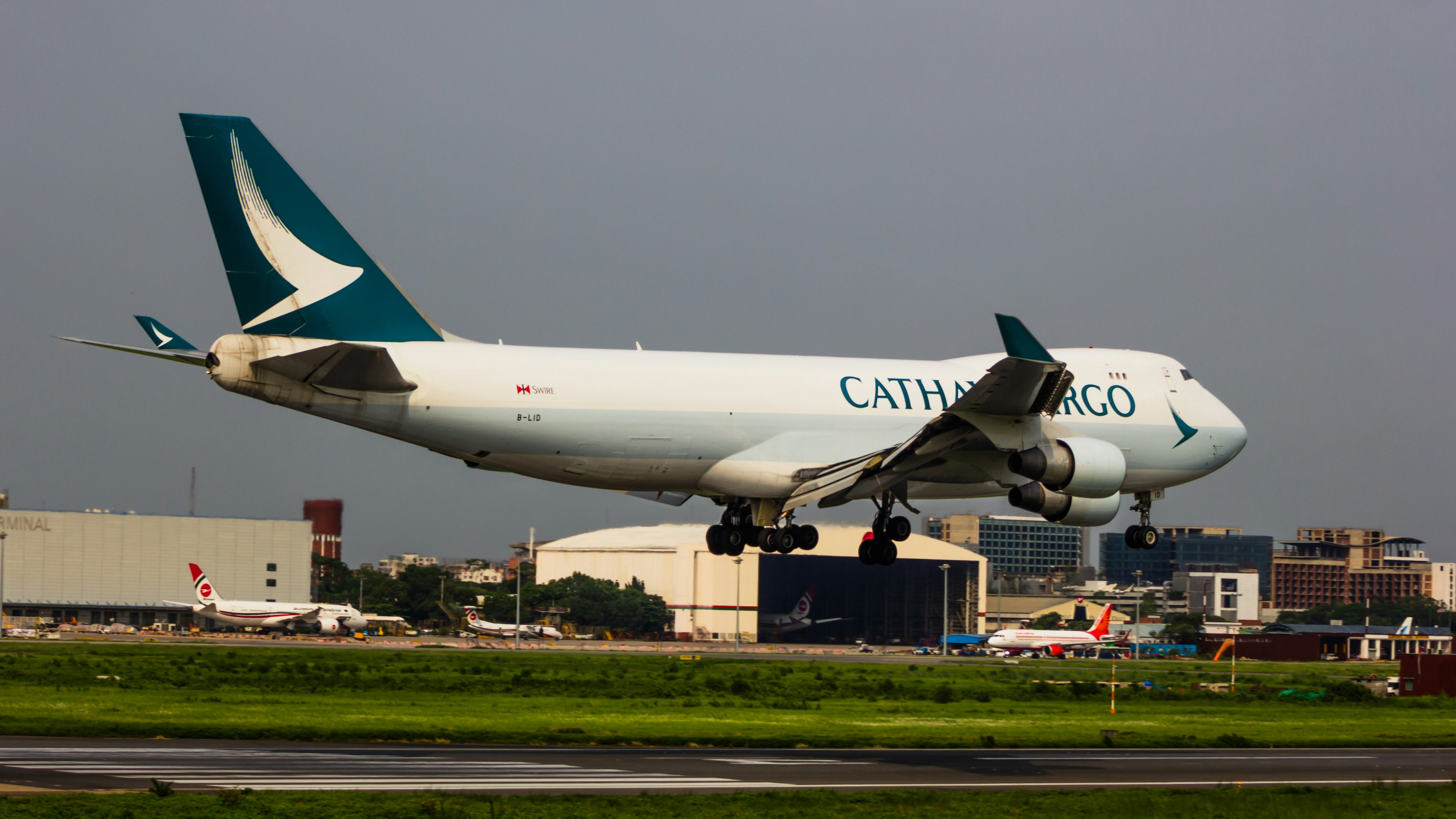 a large passenger jet taking off from an airport runway, Cathay cargo 747F