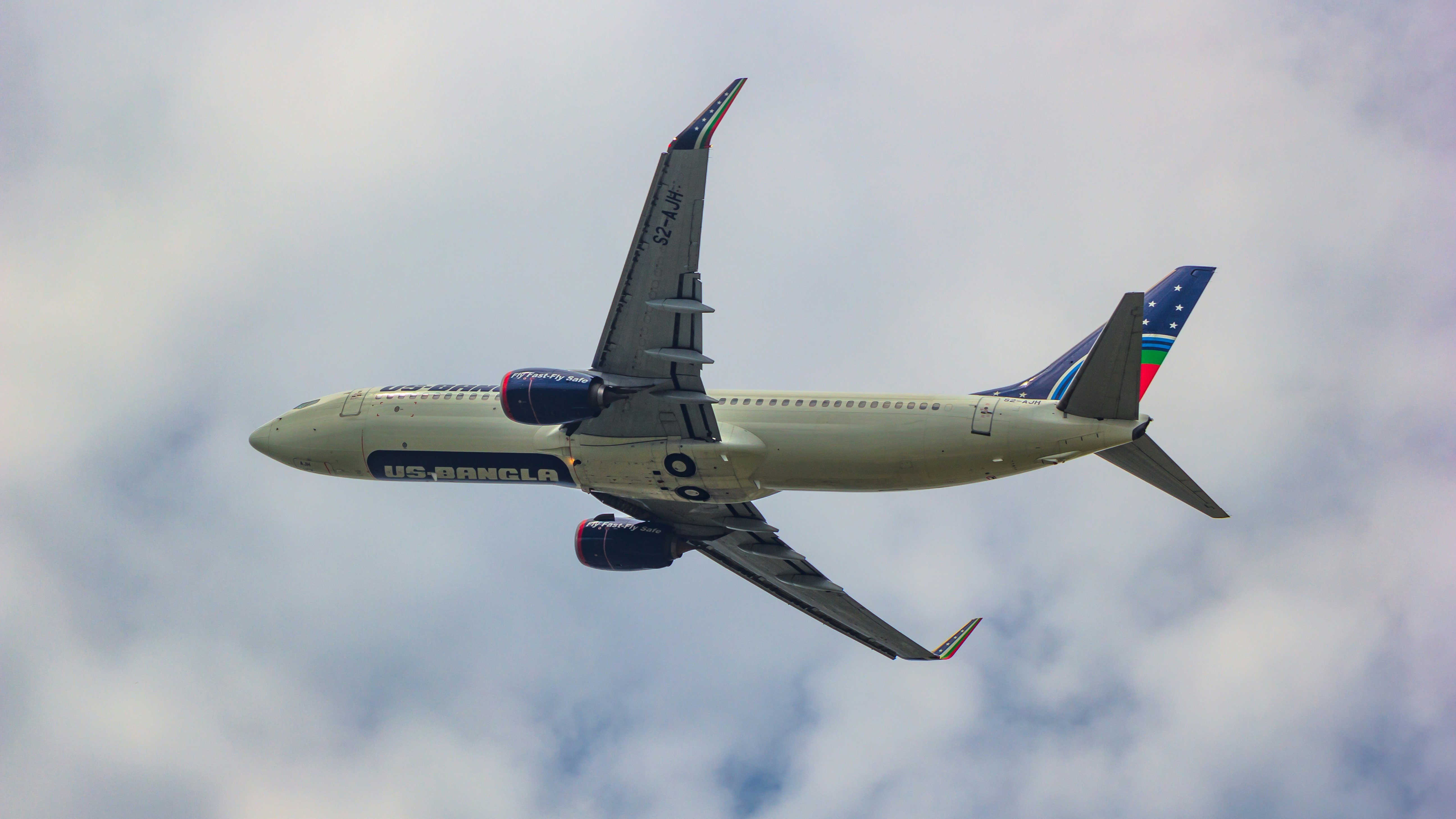 a large jetliner flying through a cloudy blue sky, US-Bangla Boeing 737-800