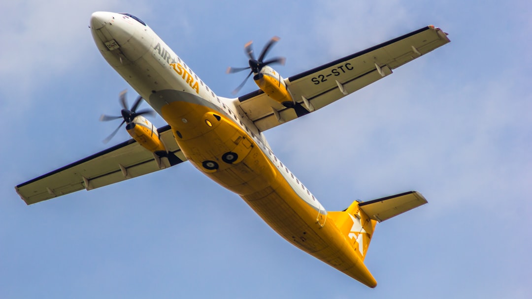 a yellow and white plane flying in the sky, Air Astra ATR 72-600