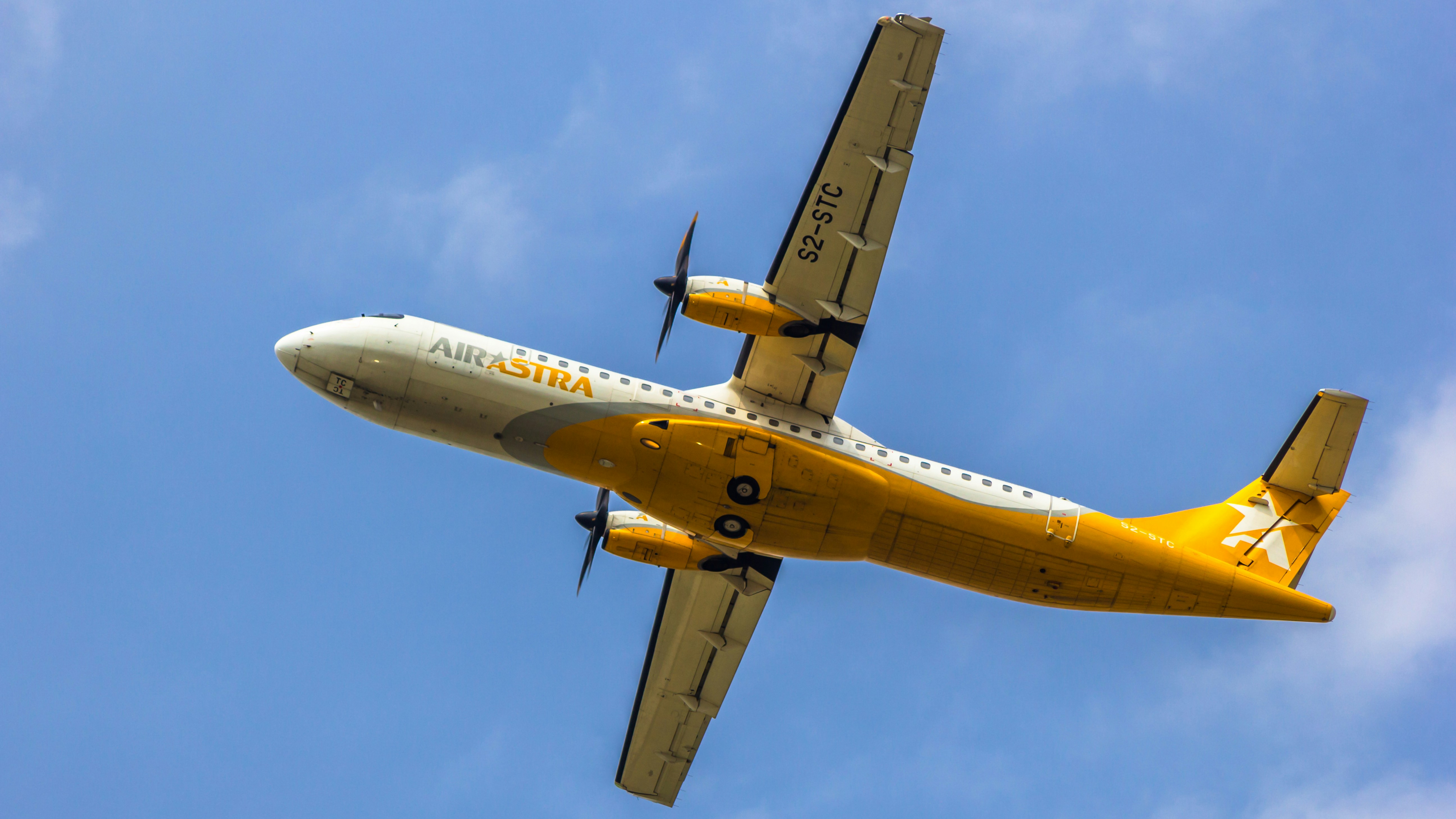 a yellow and white airplane flying in the sky, Air Astra ATR 72-600