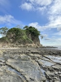 a rocky beach with a small island in the background