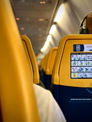 a yellow seat on an airplane with headphones on