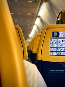 a yellow seat on an airplane with headphones on