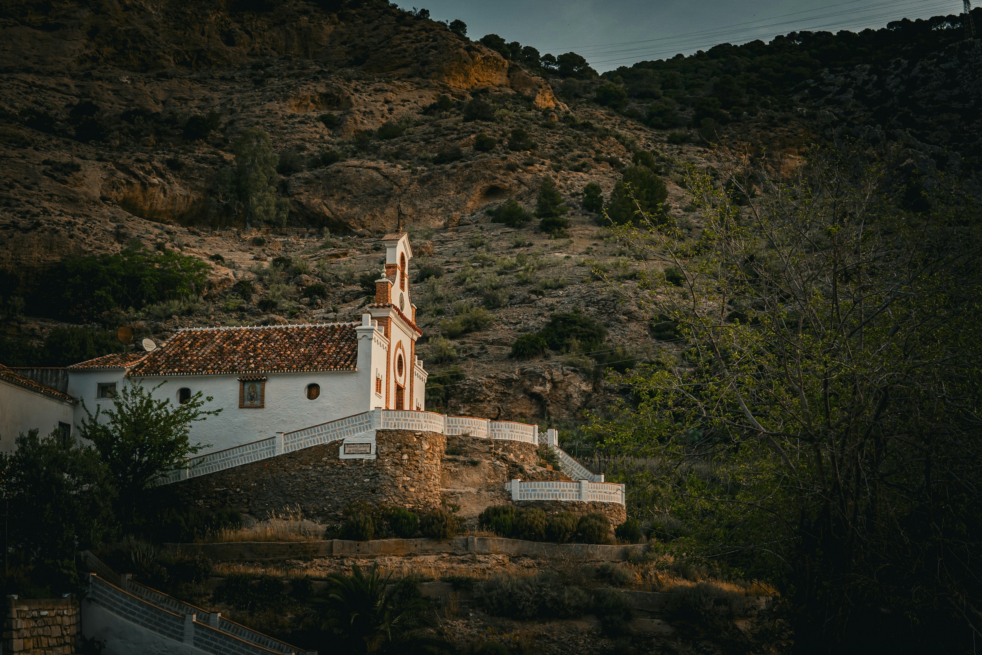 a church on a hill with a steeple in the background