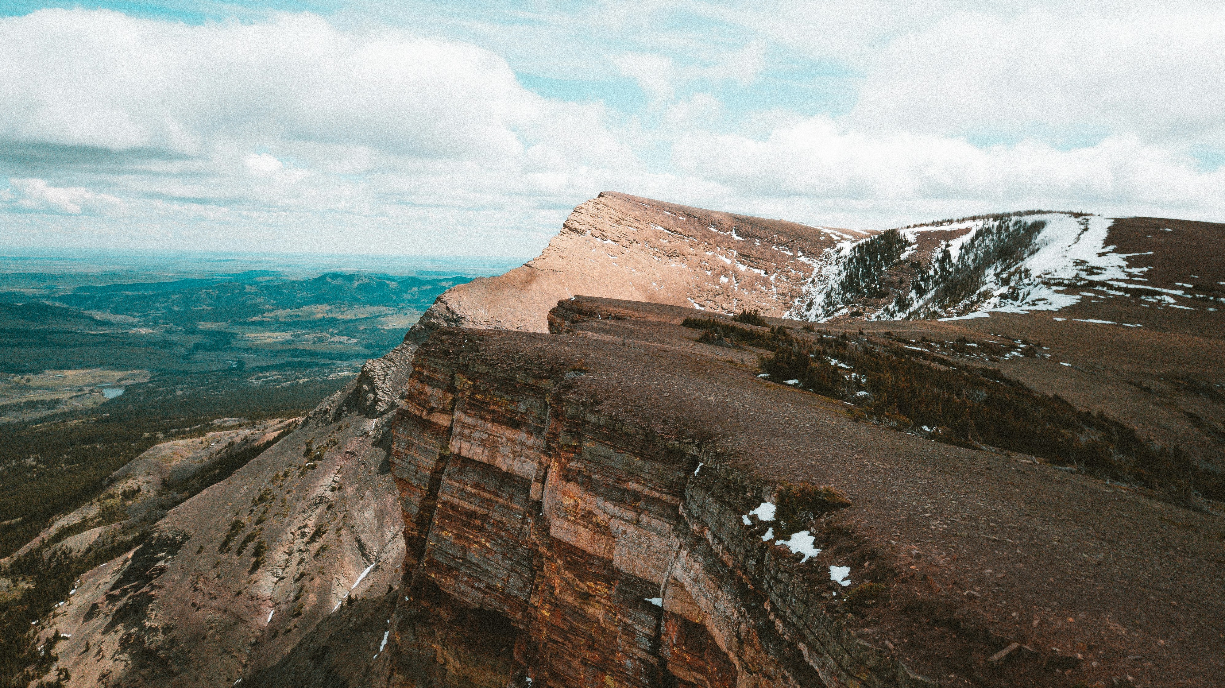 a man standing on top of a mountain next to a cliff