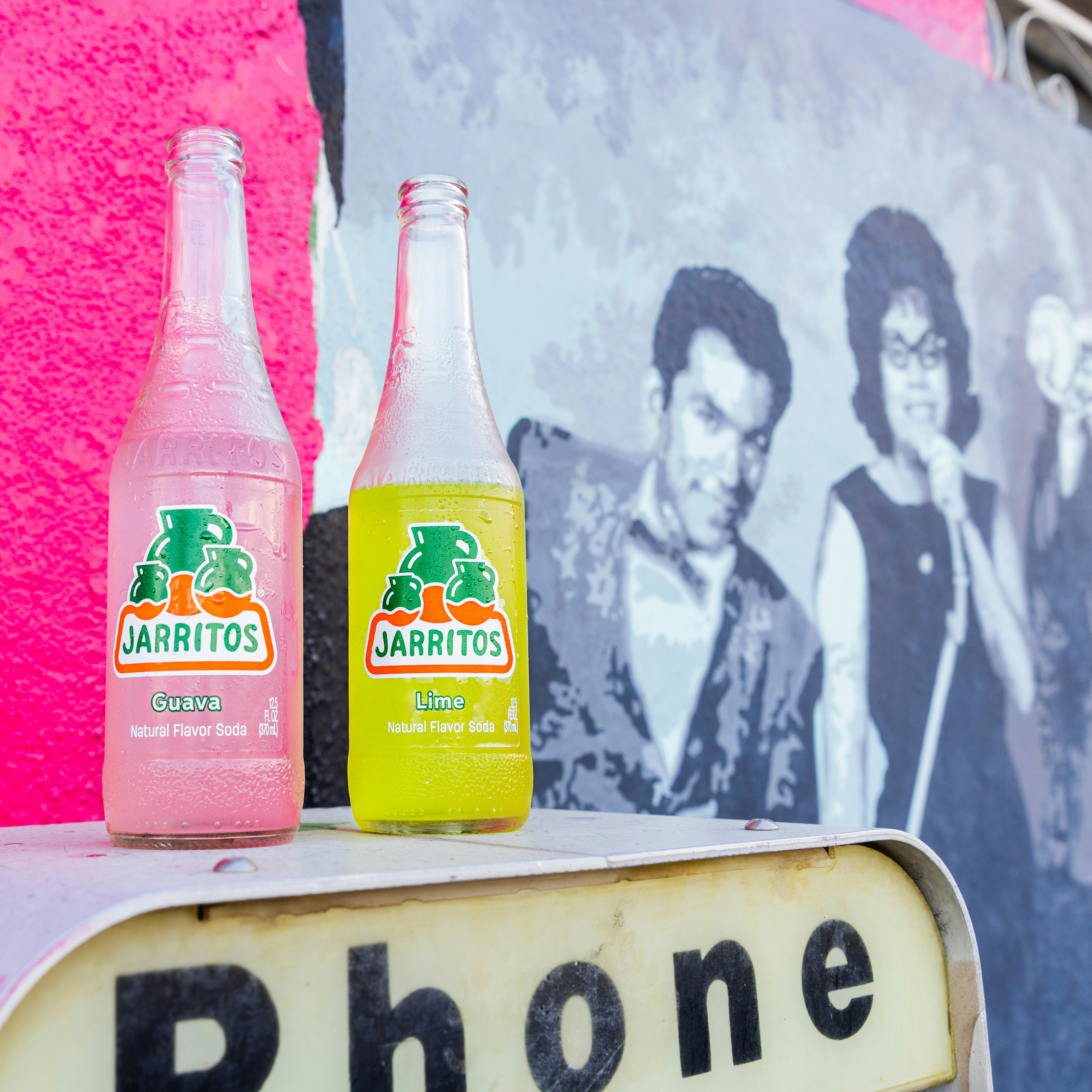 a couple of bottles of juice sitting on top of a sign