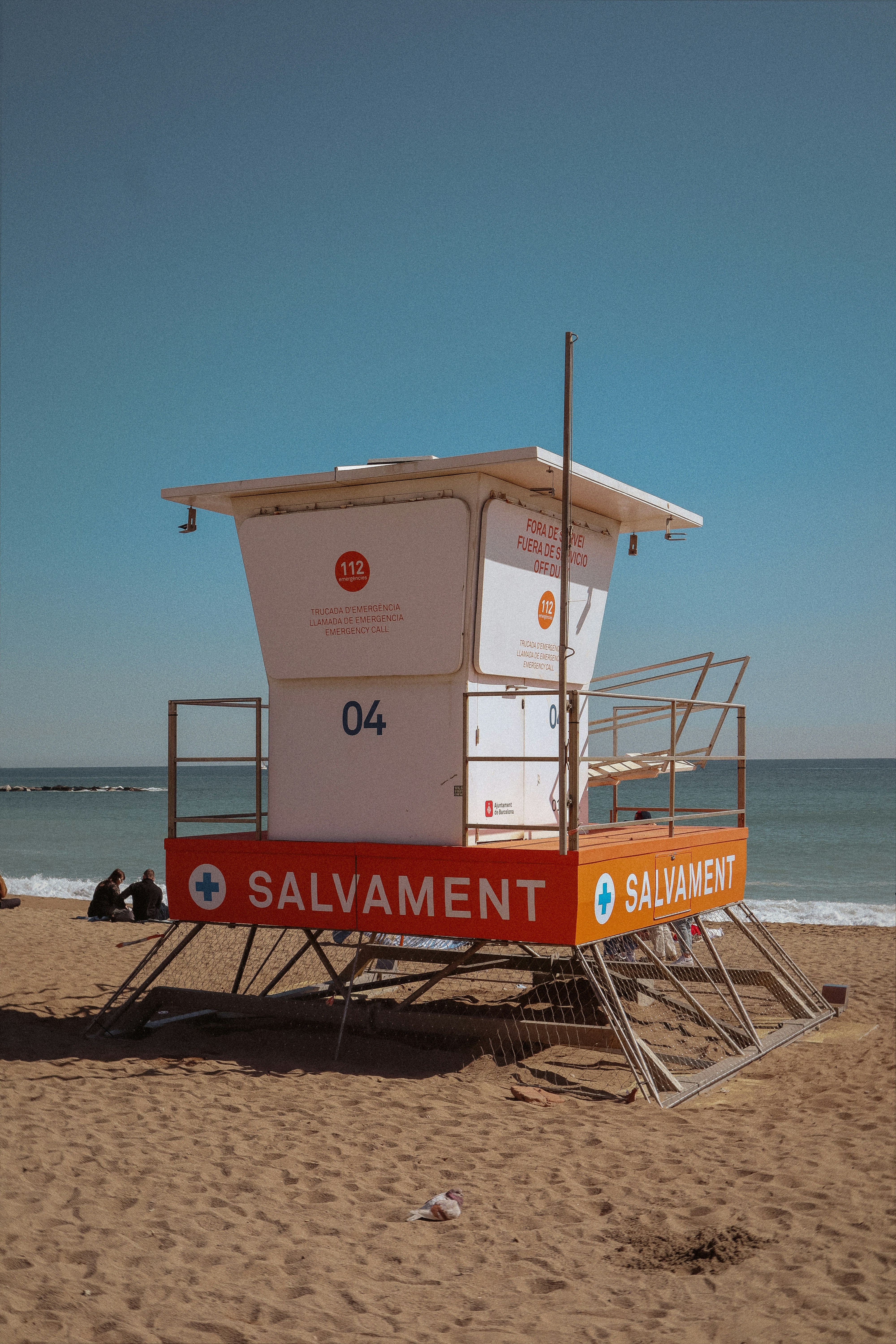 a lifeguard stand on the beach with a blue sky in the background