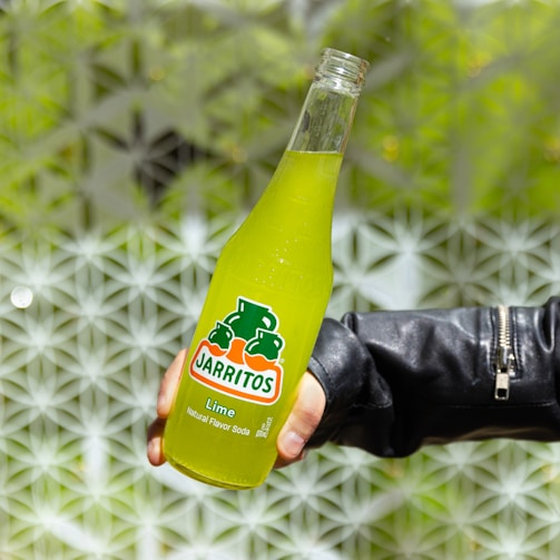 a person holding a bottle of orange juice