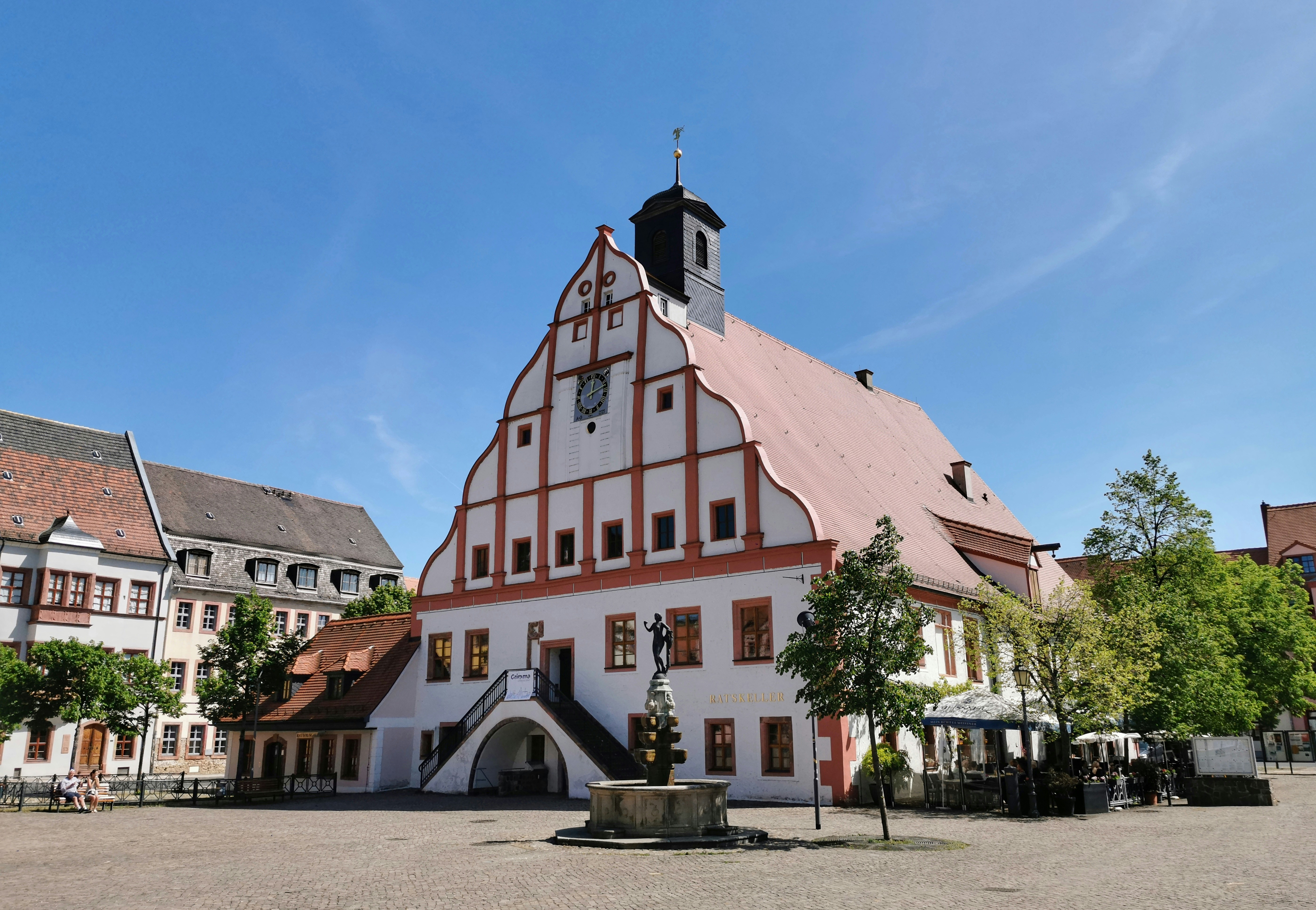a large white and red building with a clock tower