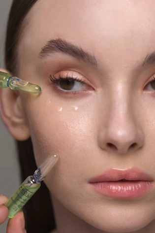 a woman holding a syring next to her face