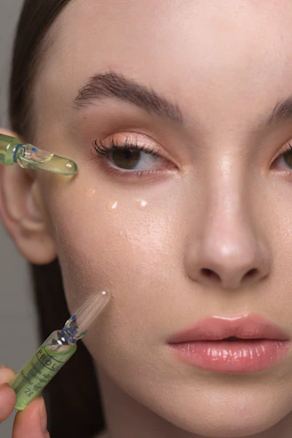 a woman holding a syring next to her face