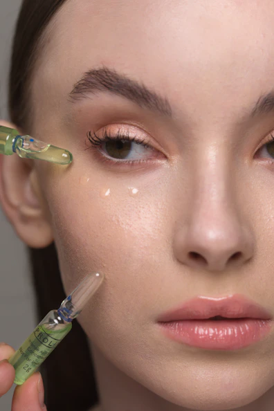 a woman holding a syring next to her face