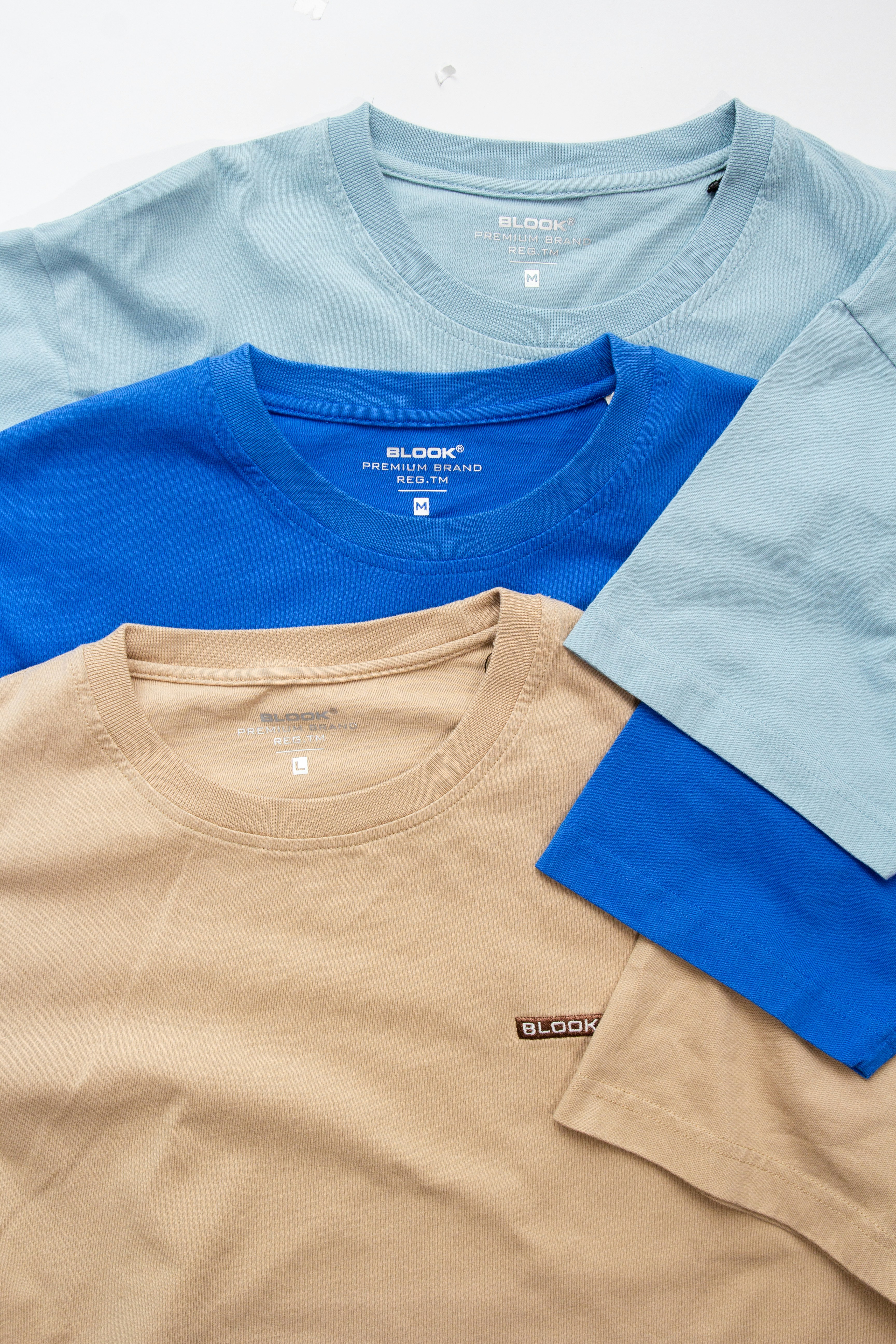 three different colors of t - shirts sitting next to each other