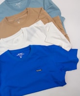 a group of five t - shirts laying on top of each other