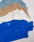 a group of five t - shirts laying on top of each other