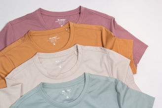a bunch of different colored shirts on a white background
