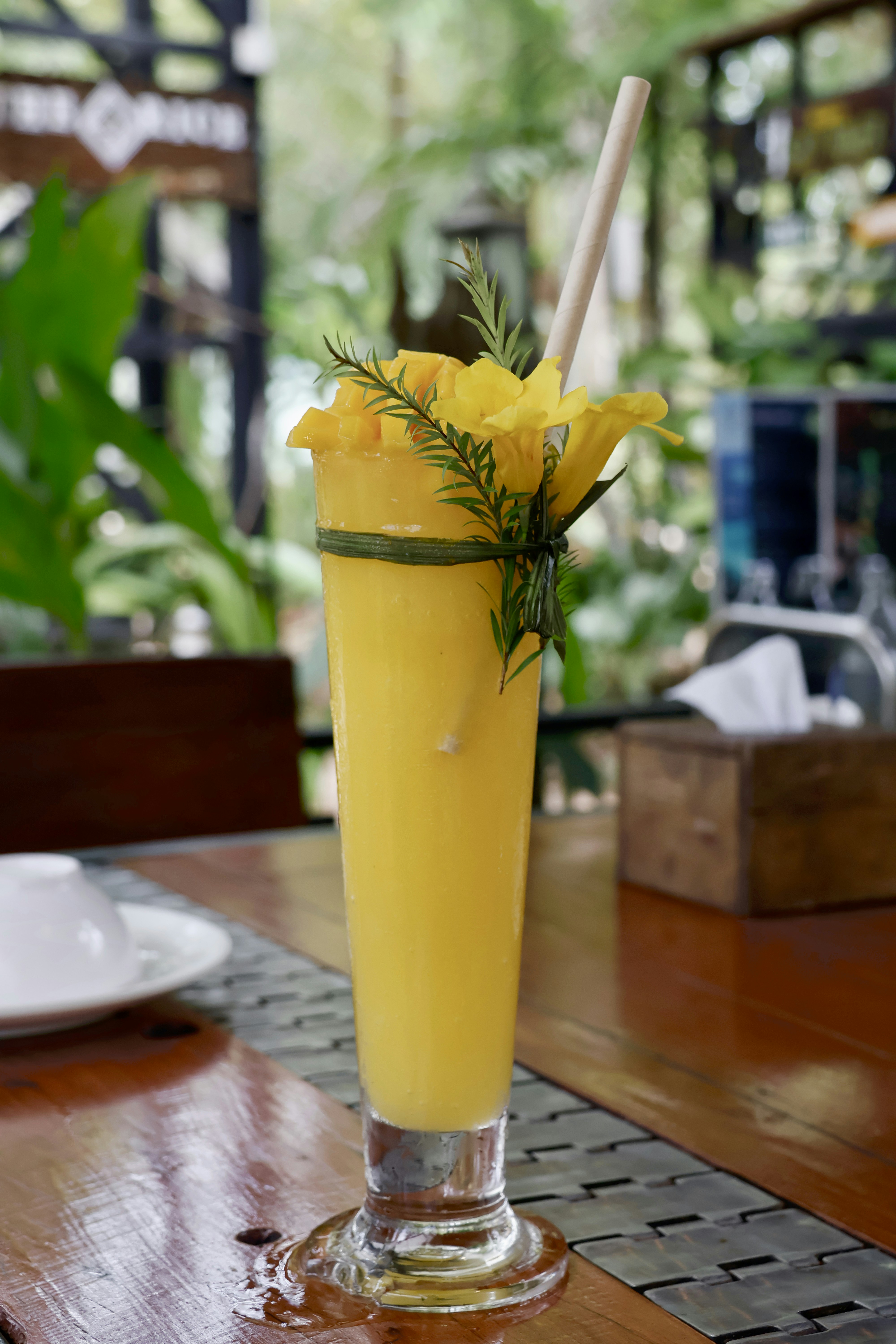 a tall glass filled with a yellow drink
