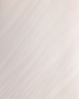 a man riding a snowboard down the side of a snow covered slope