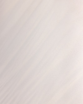 a man riding a snowboard down the side of a snow covered slope