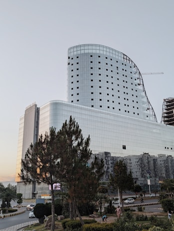 a large white building with many windows next to a street