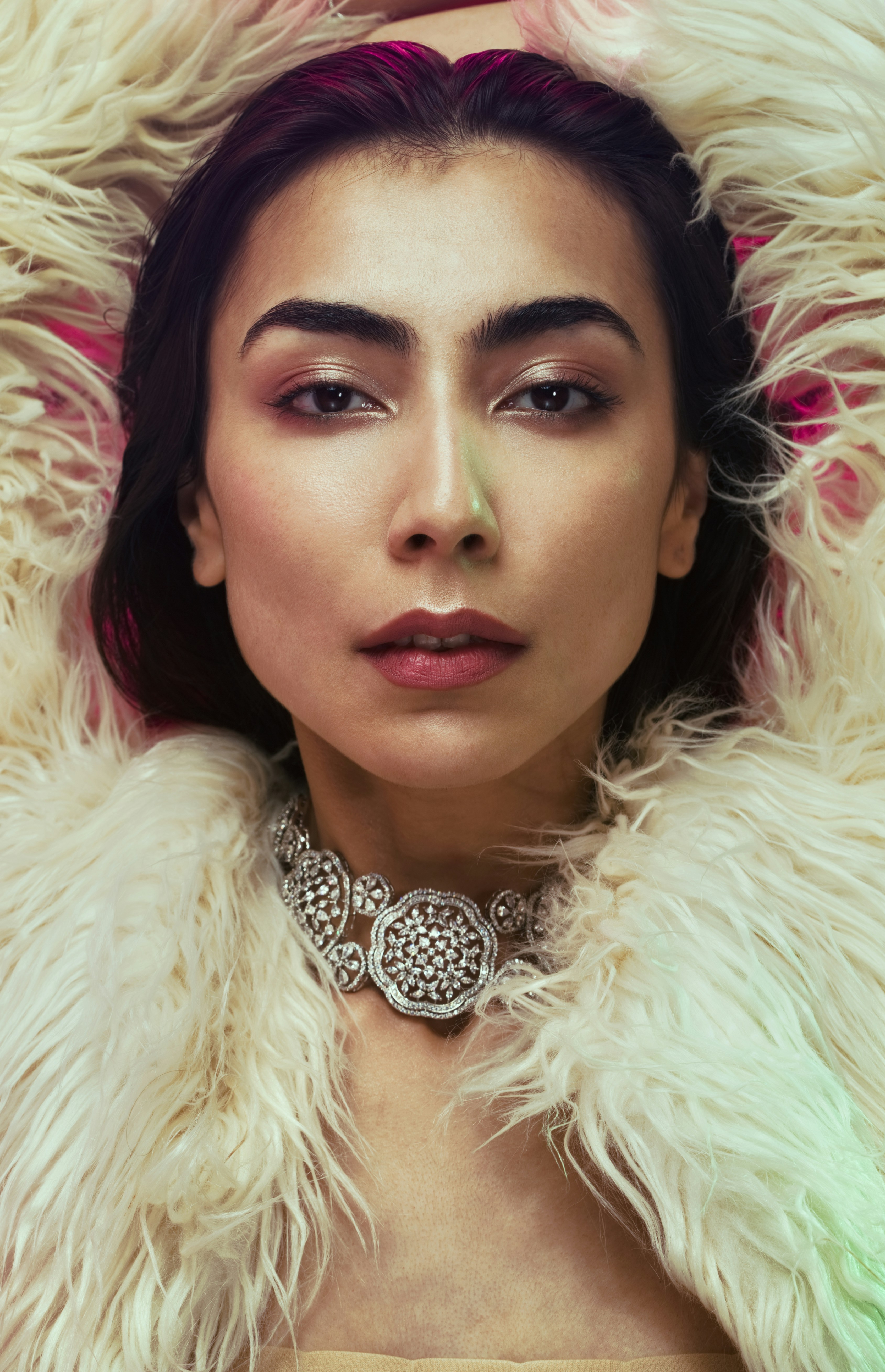 a woman wearing a fur coat and a necklace