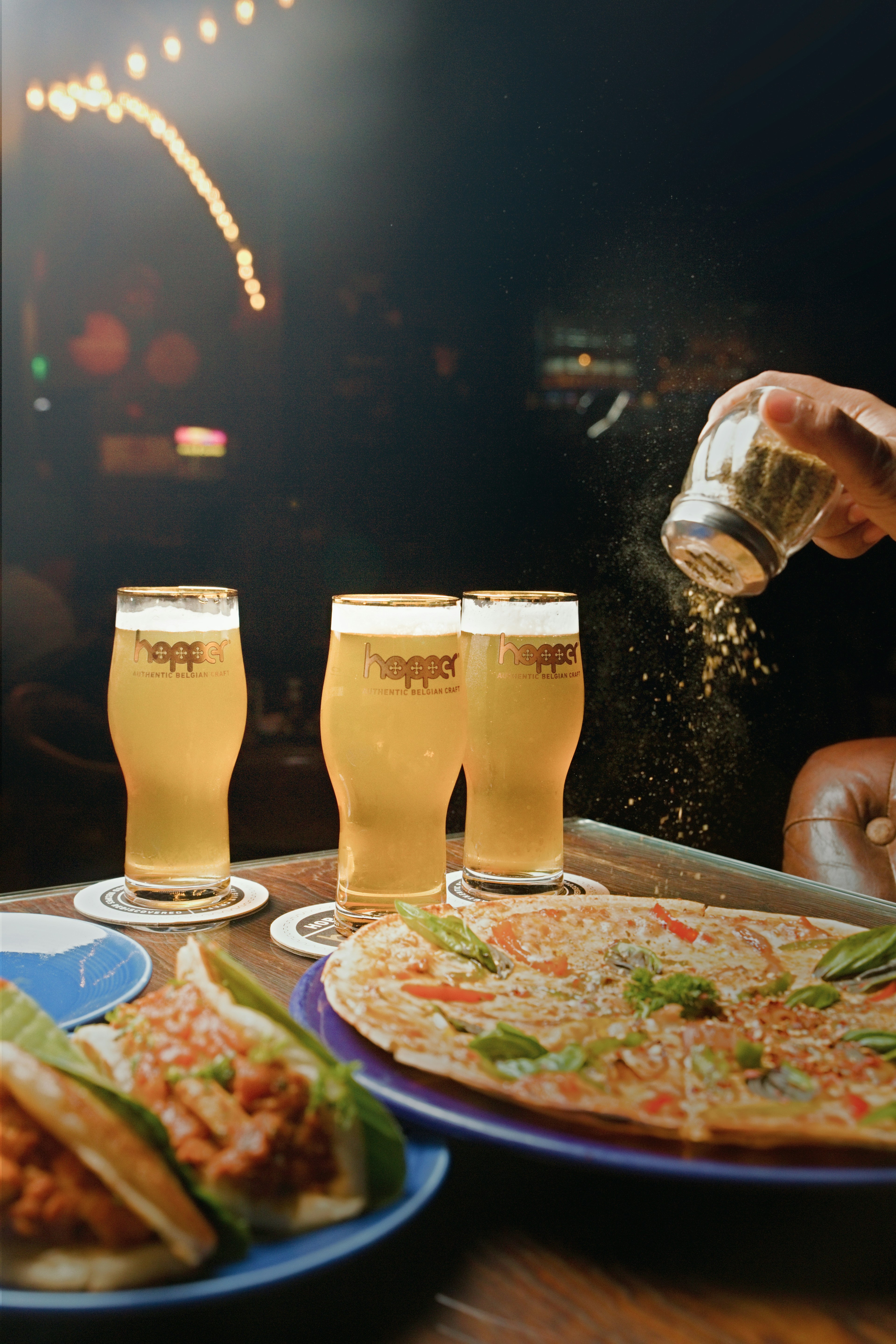 A table topped with plates of food and glasses of beer photo – Free ...