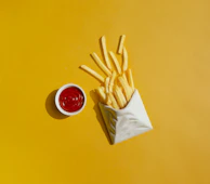 french fries with ketchup on a yellow background