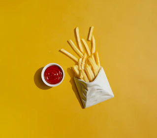 french fries with ketchup on a yellow background
