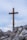 a wooden cross on top of a rocky hill