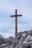 a wooden cross on top of a rocky hill