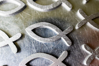 a close up of a metal plate with a cross and a symbol on it