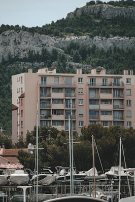 a marina filled with lots of boats next to a tall building