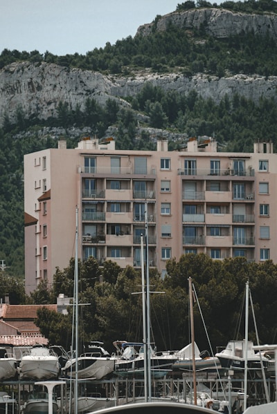 a marina filled with lots of boats next to a tall building