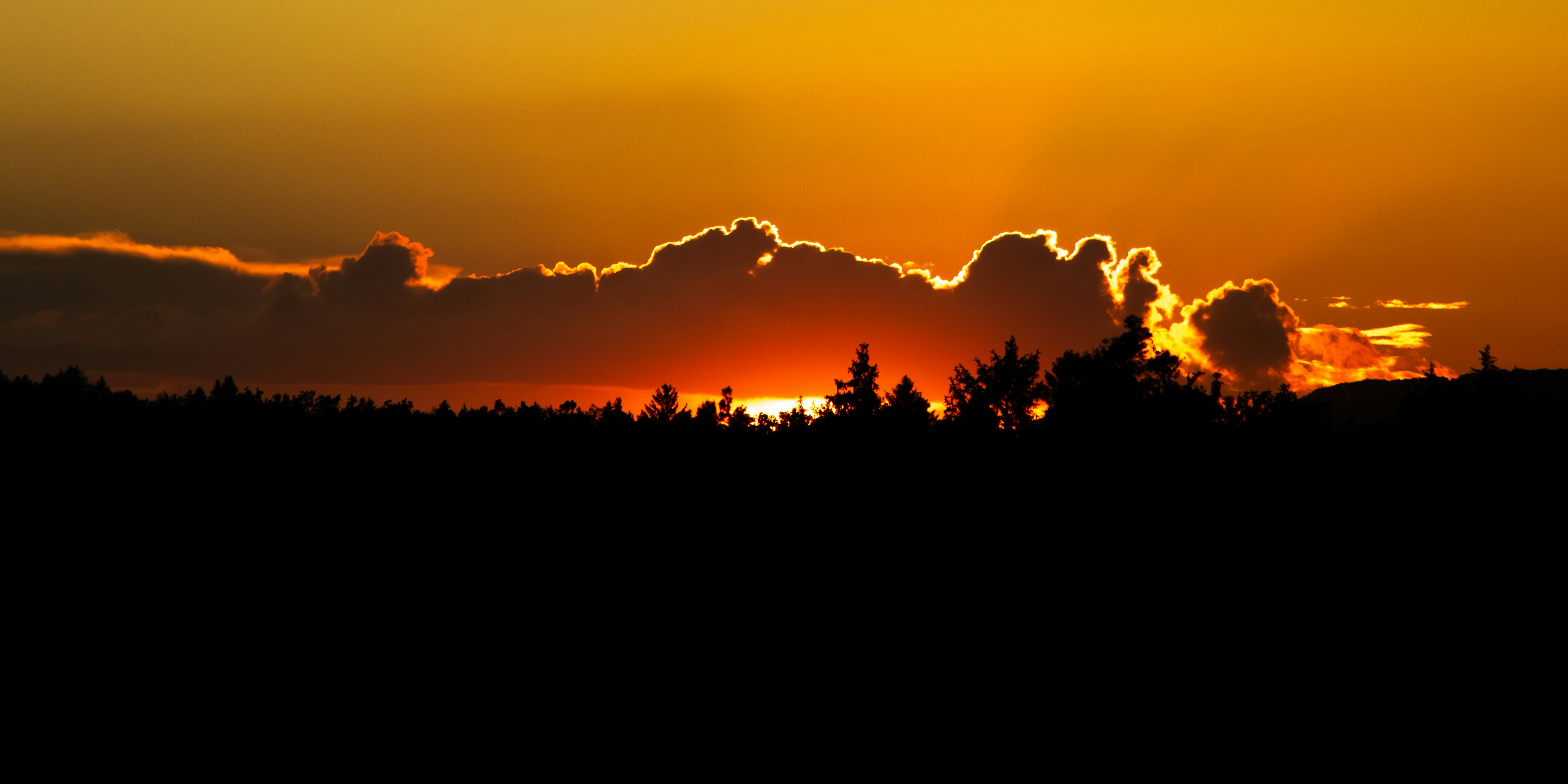 the sun is setting behind the clouds in the sky