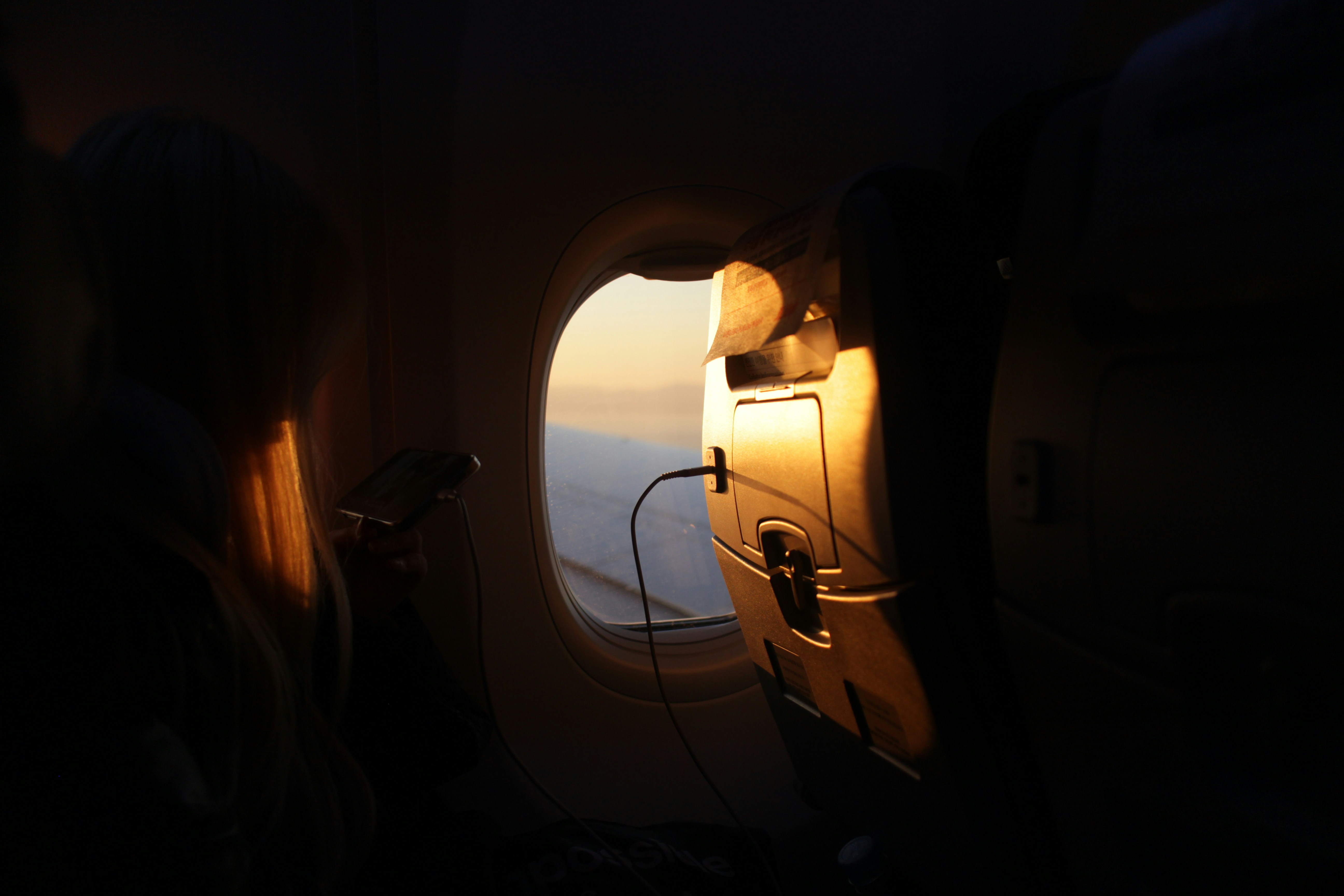 a woman looking out the window of an airplane, 