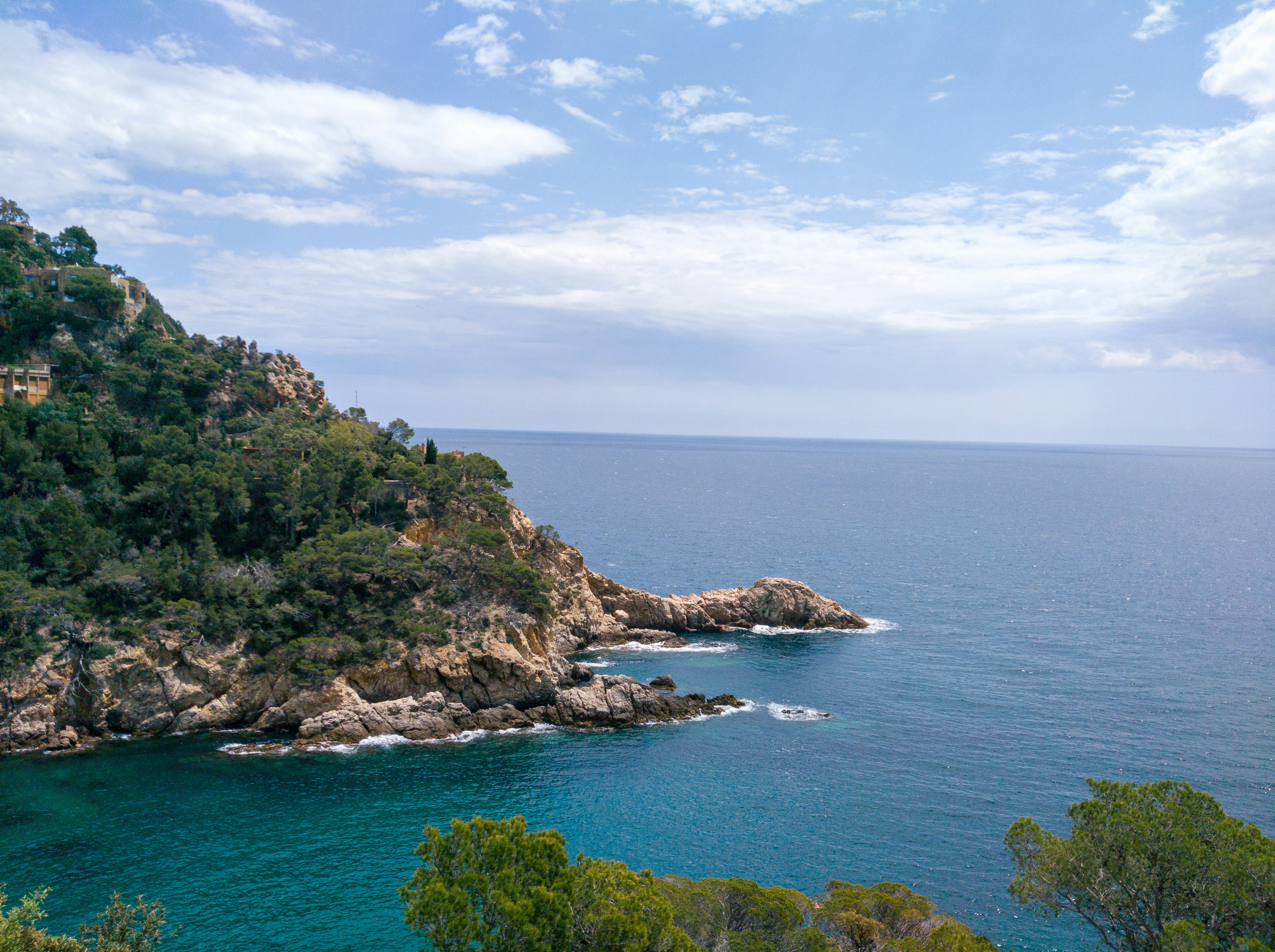 a large body of water sitting next to a lush green hillside