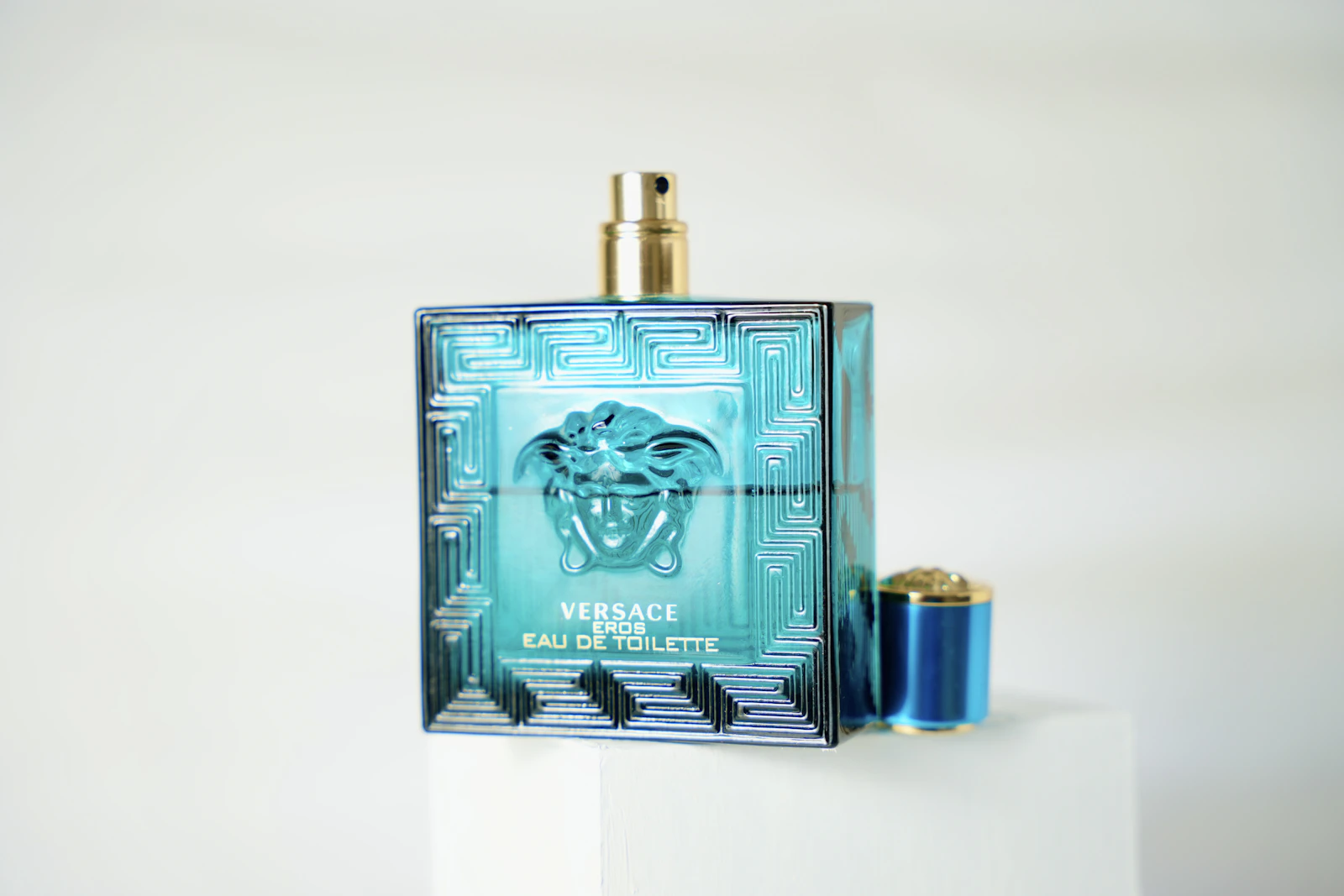 Versace Eros eau de toilette bottle on white pedestal