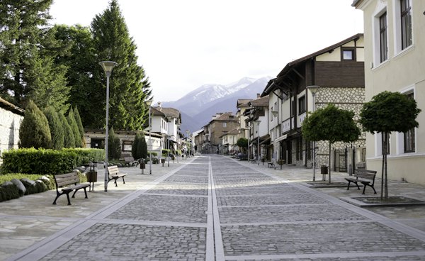 A cobblestone street lined with benches and trees — Bansko, Bulgaria