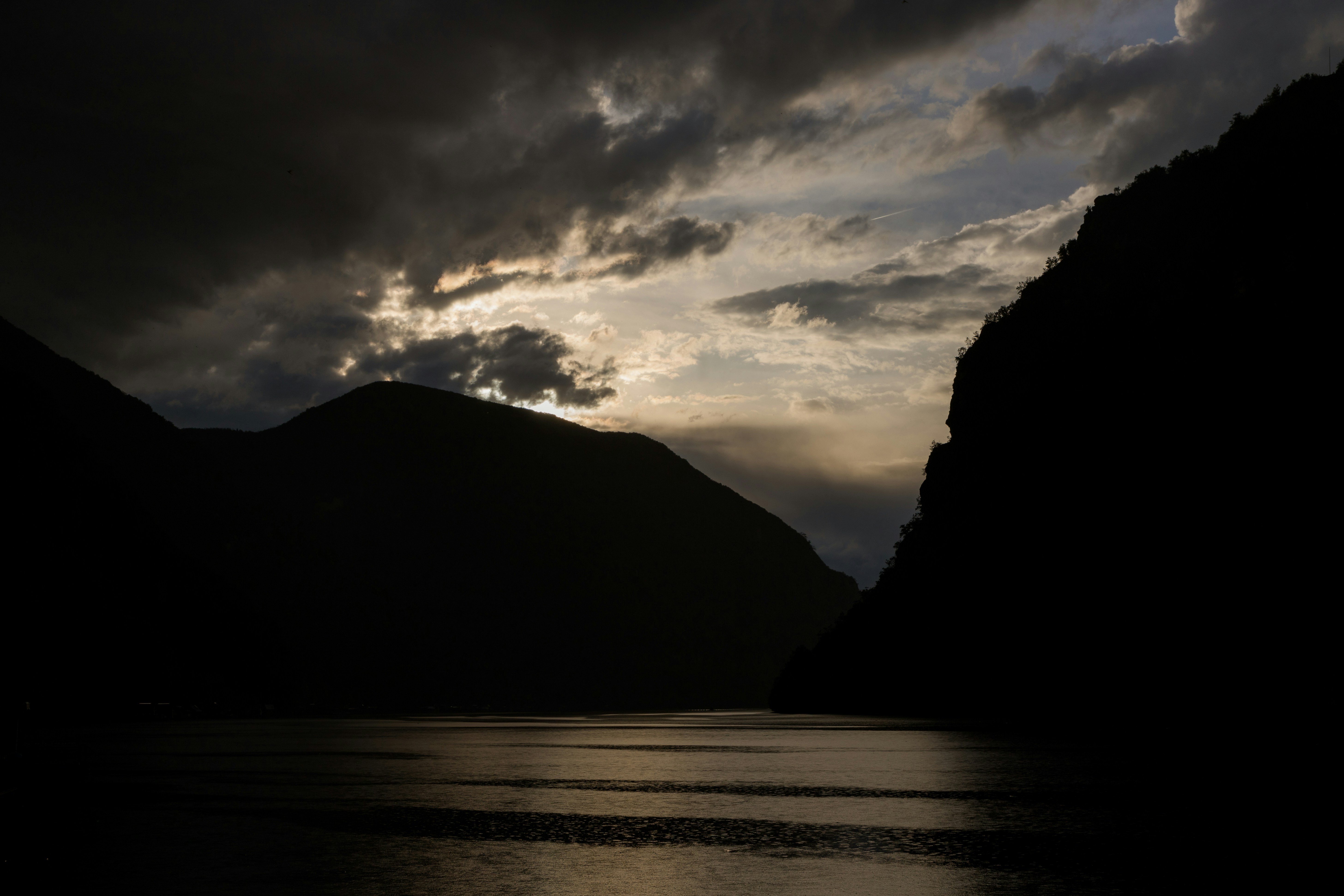 the sun is shining through the clouds over the mountains