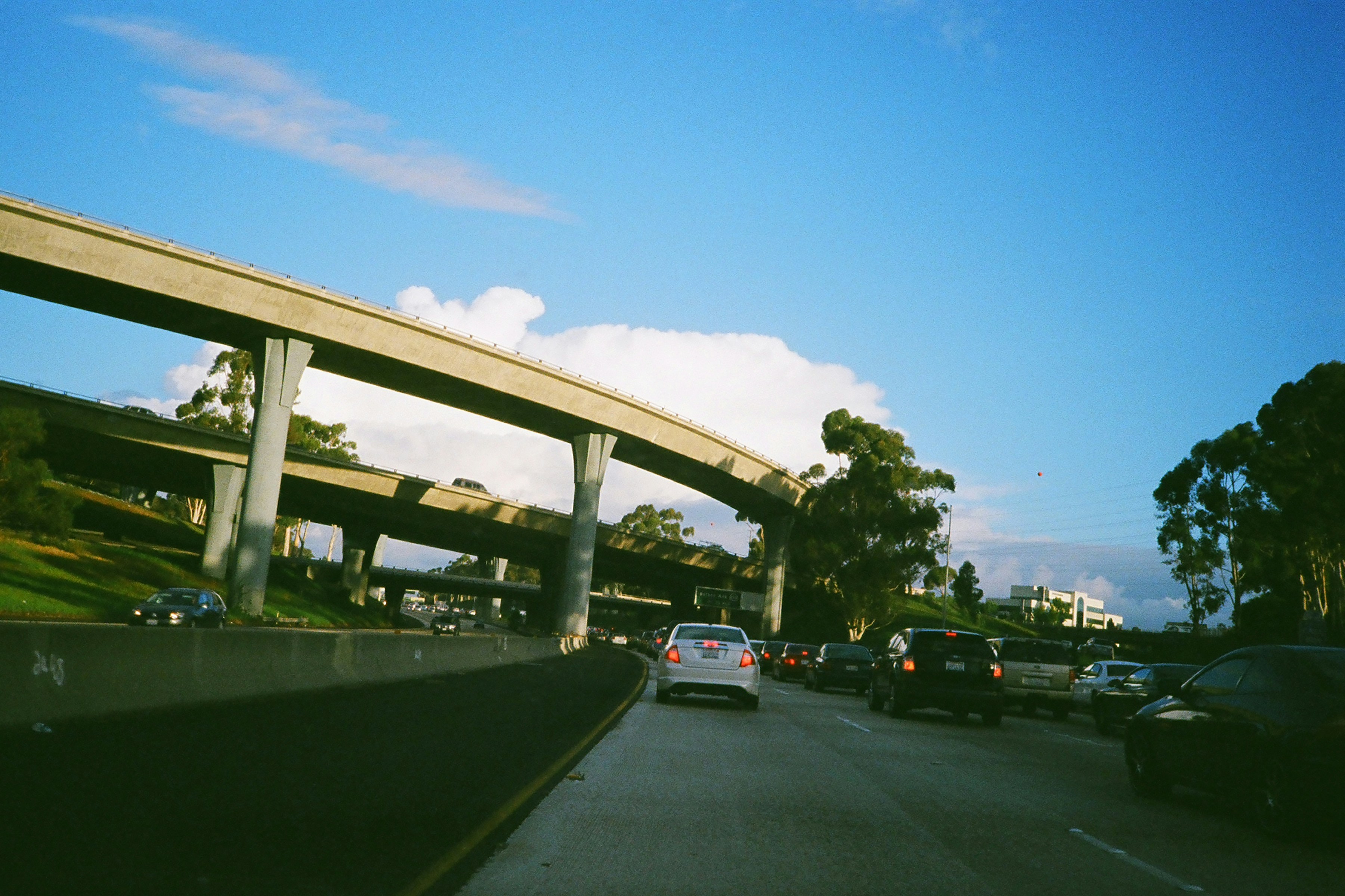 a highway filled with lots of traffic under a bridge