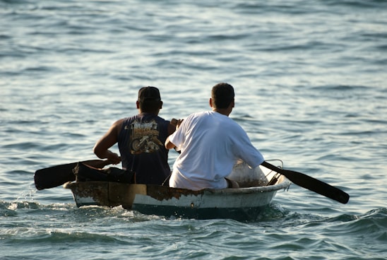 two people in a small boat on the water