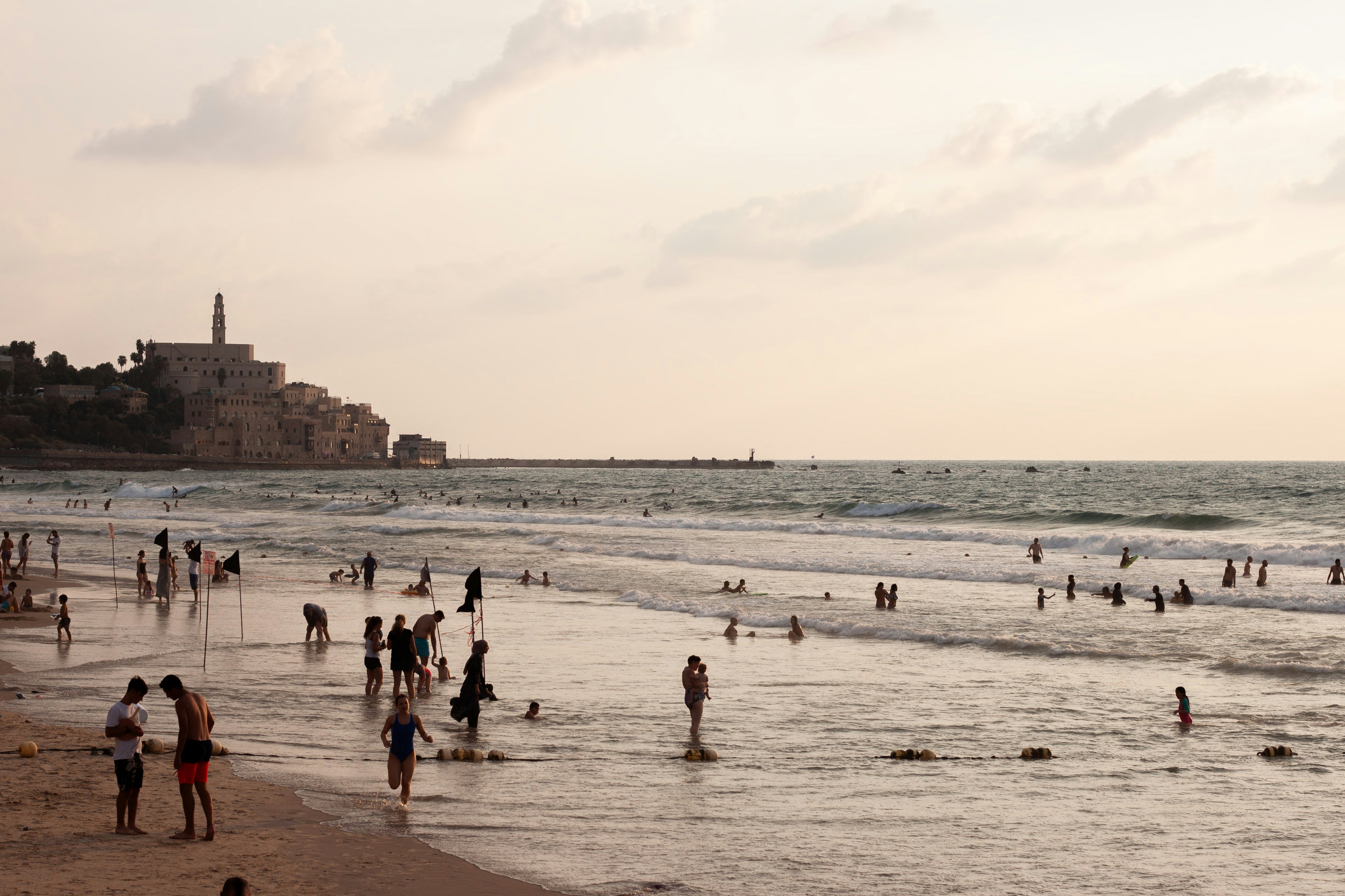many people are on the beach and in the water
