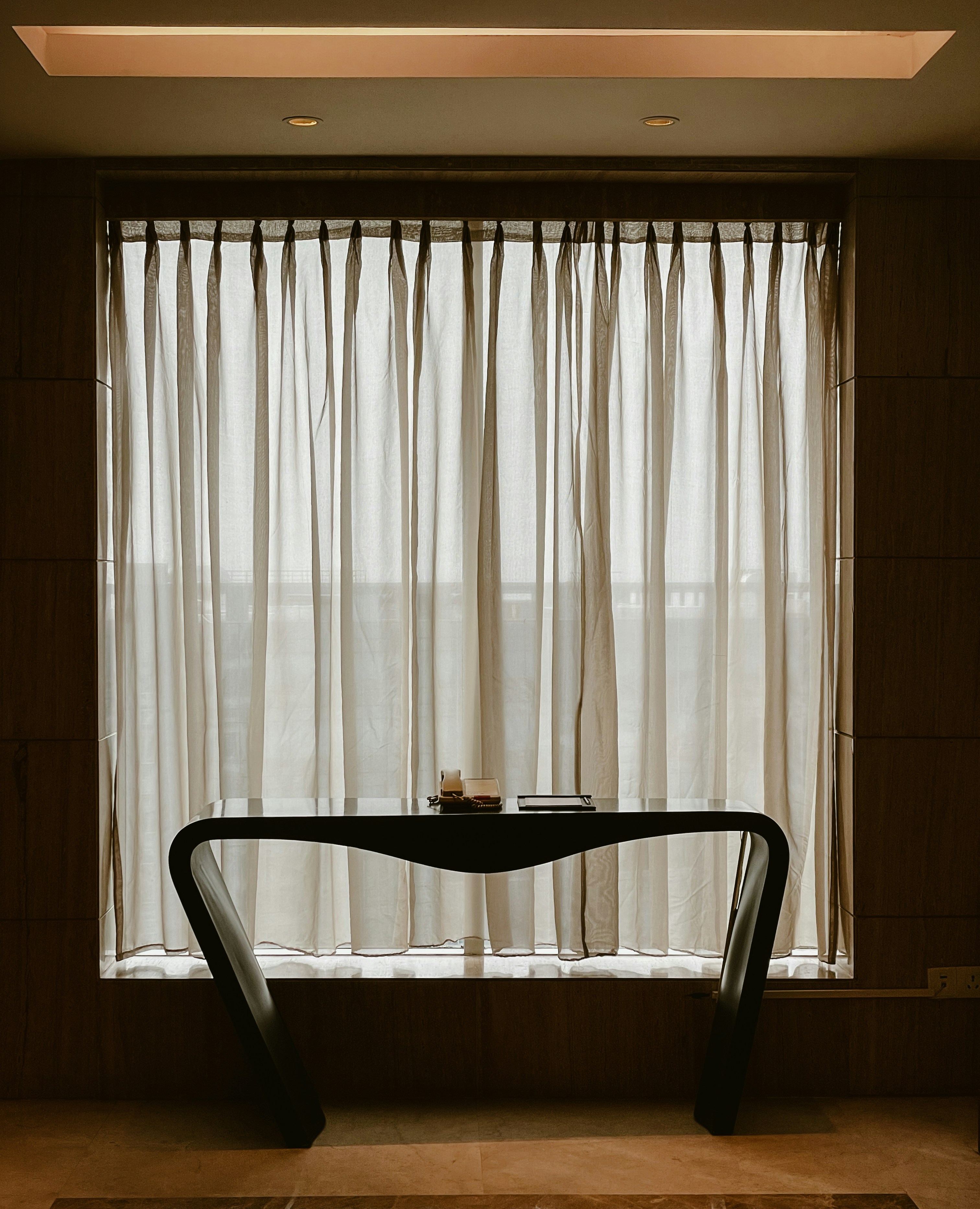 a table with a candle on it in front of a window