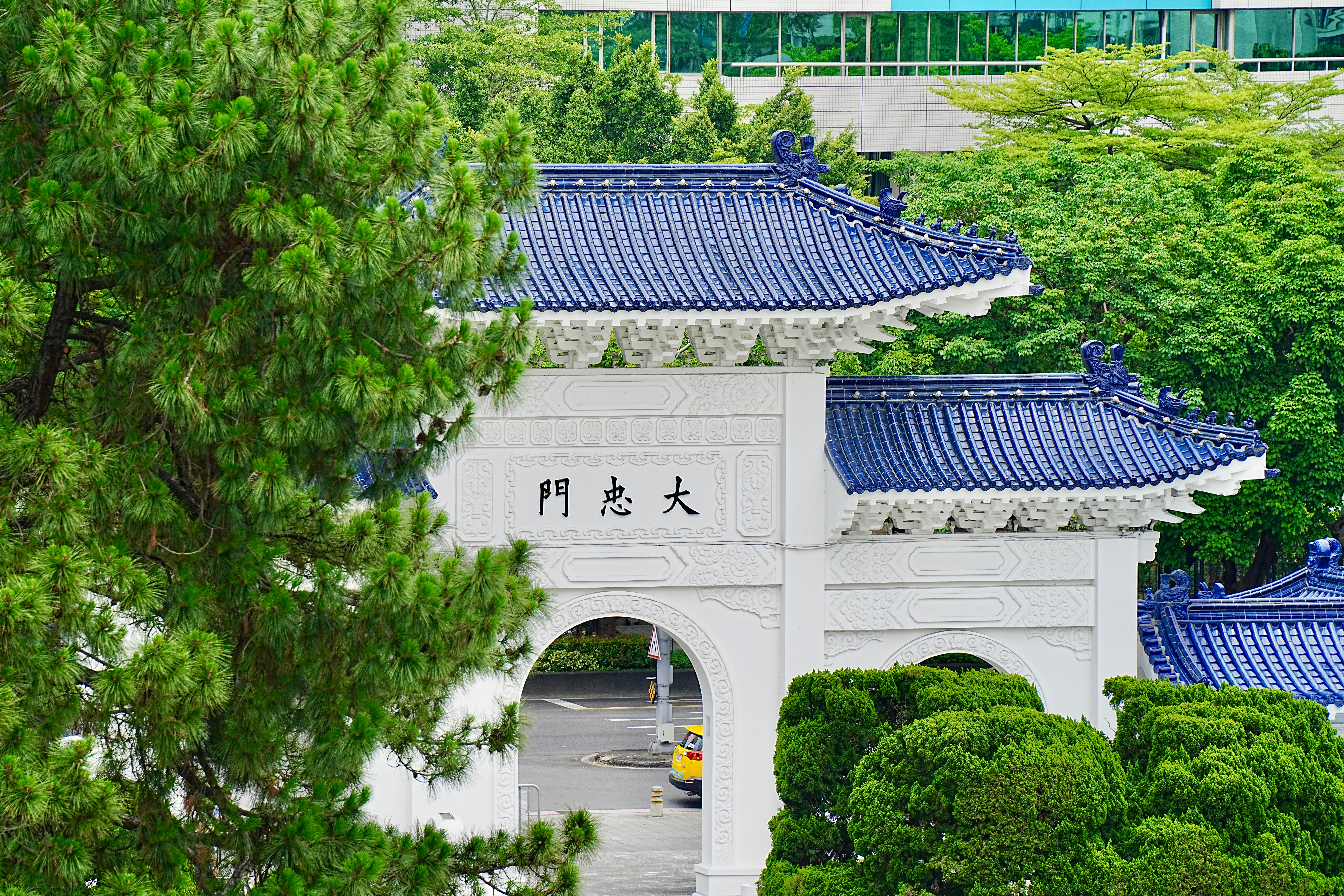 a white building with a blue roof surrounded by trees