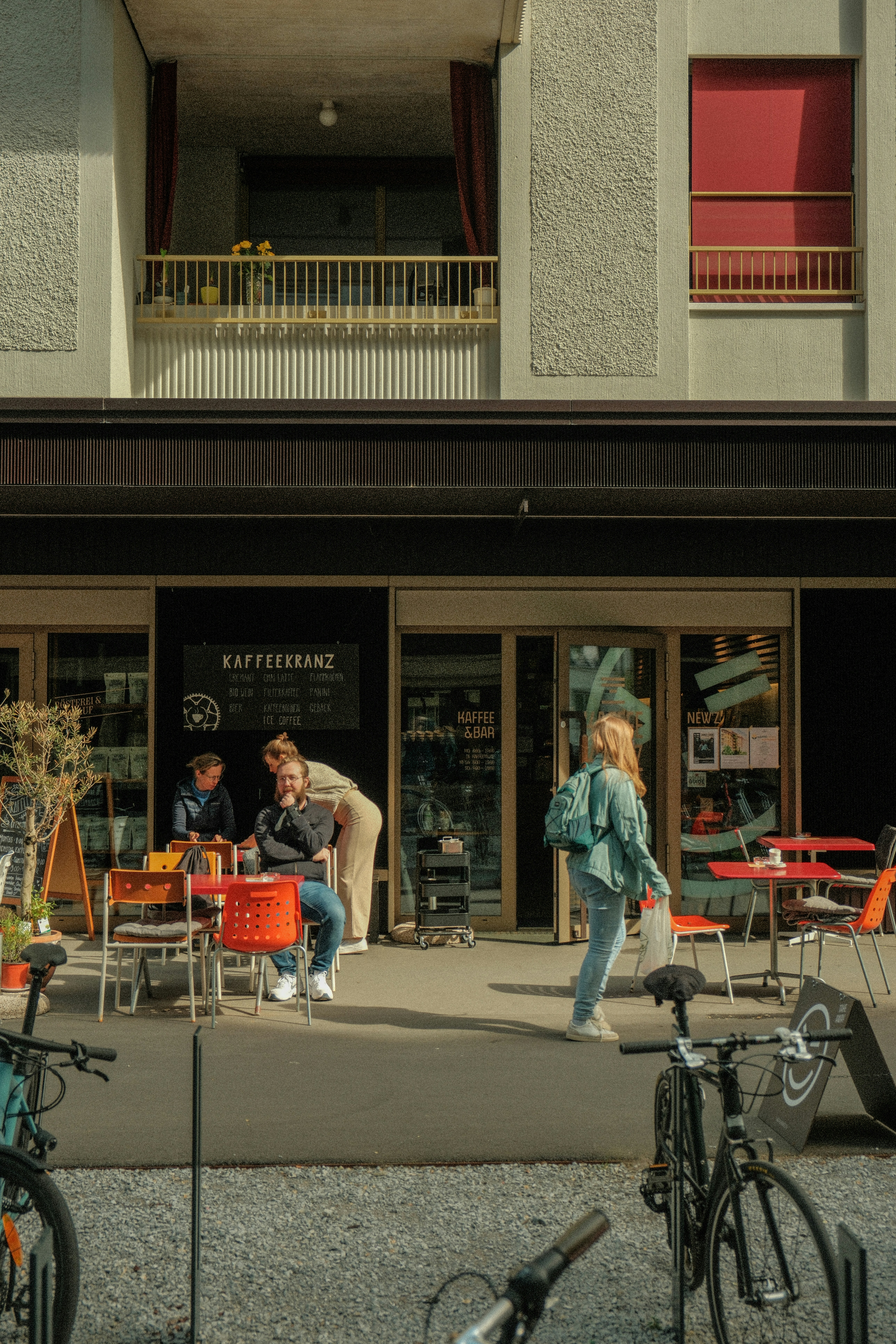 Eine Gruppe von Menschen, die an Tischen vor einem Gebäude sitzen