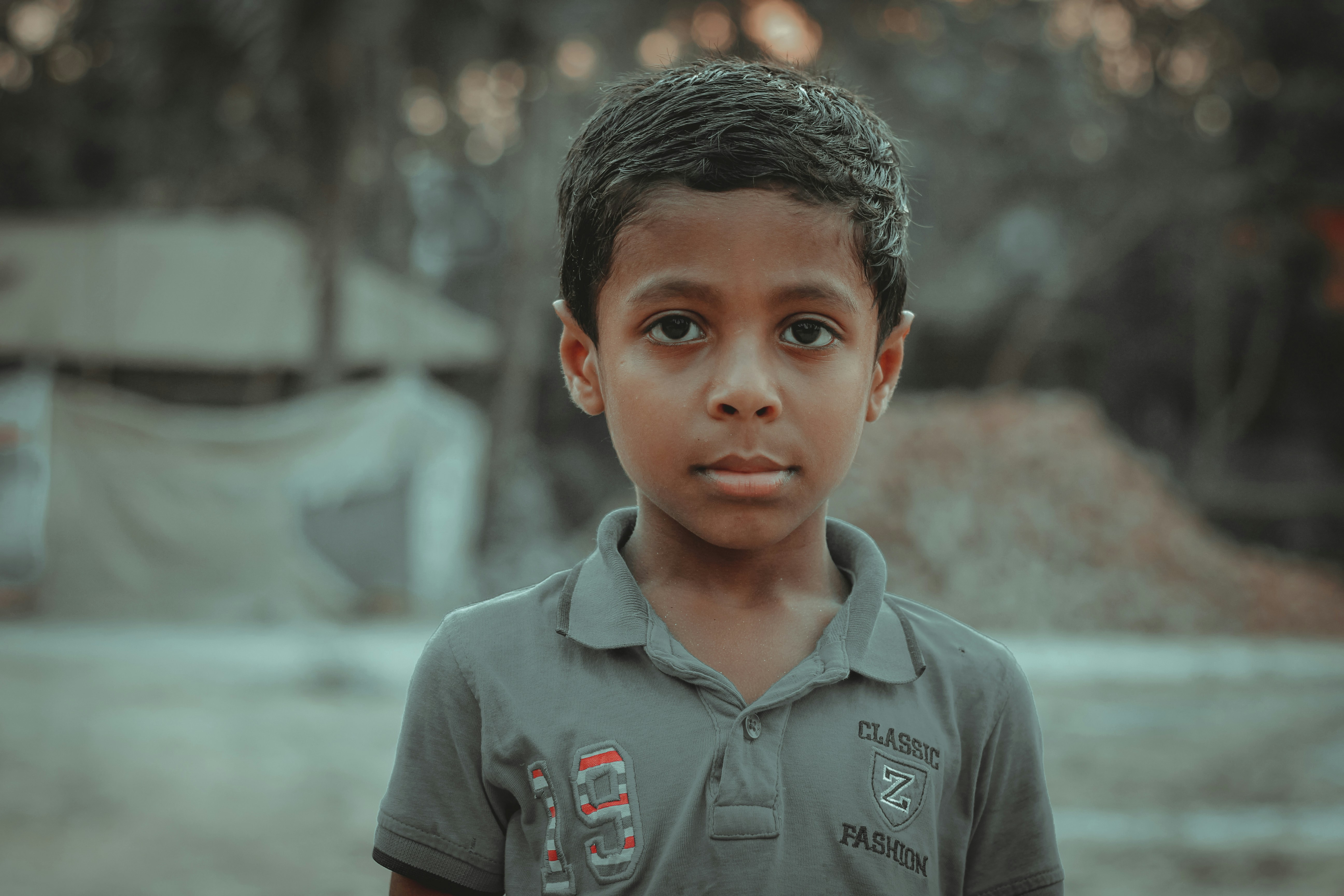 a young boy standing in front of a tent