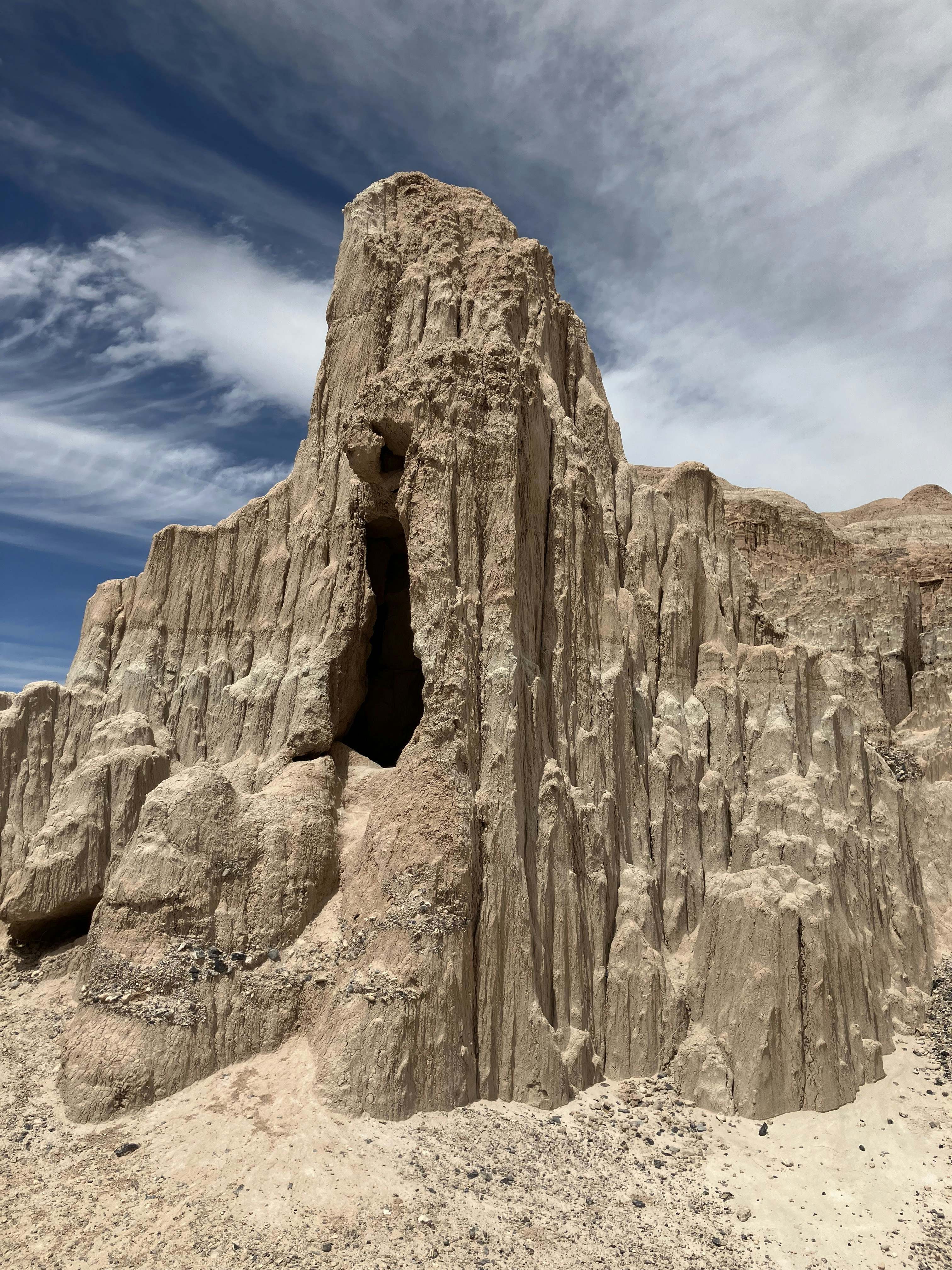 A rock formation in the desert with a sky background photo – Free Cave ...